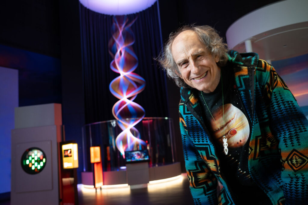 Artist Paul Friedlander pictured in front of String of Waves exhibit in Lightbox