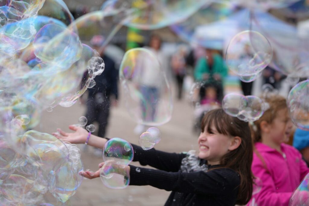 Children playing with large bubbles in Newcastle's Times Square.