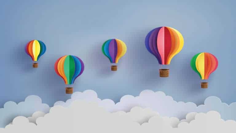 5 rainbow coloured paper hot air balloons floating in the clouds
