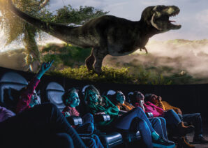 Family looking up in Life Science Centre's planetarium at large T. Rex dinosaur.