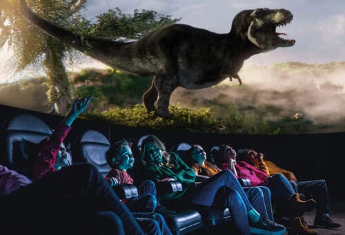Family looking up in Life Science Centre's planetarium at large T. Rex dinosaur.