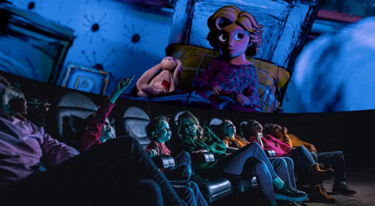 Family in Life Science Centre Planetarium looking up at animated girl in bed with bunny in Bump in the Night show.