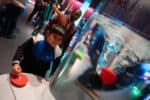 Child playing with duck whirlpool in Life Science Centre's Lightbox exhibition.