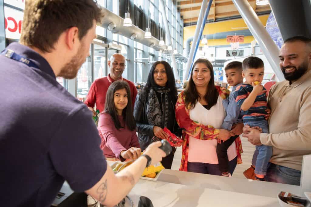 Family being served by Host inside Newcastle's Life Science Centre.