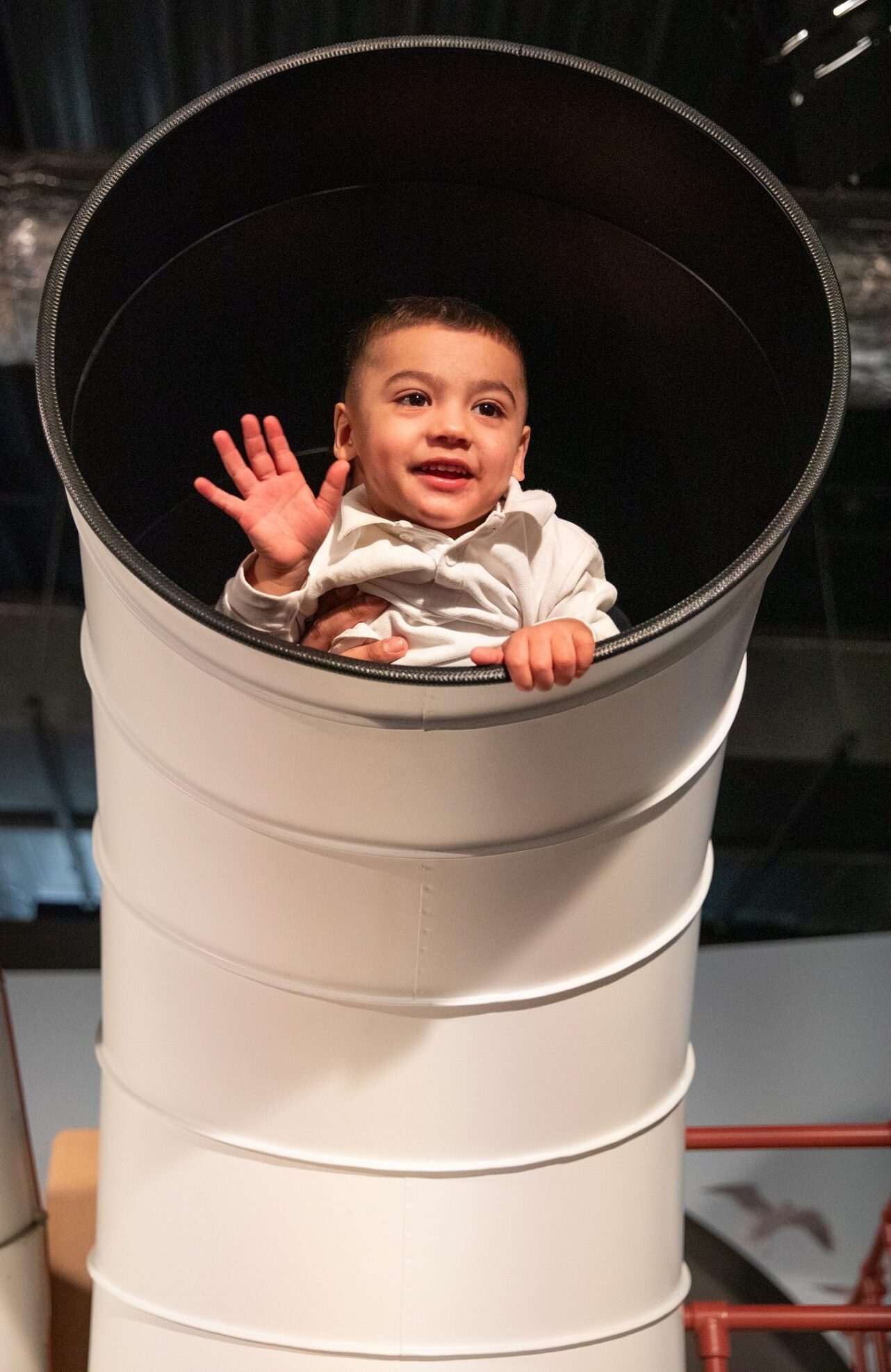 Young boy peaking out of model boat in Life Science Centre's Play Zone.