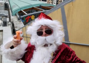 Santa using a fan and wearing sunglasses on Life Science Centre roof.
