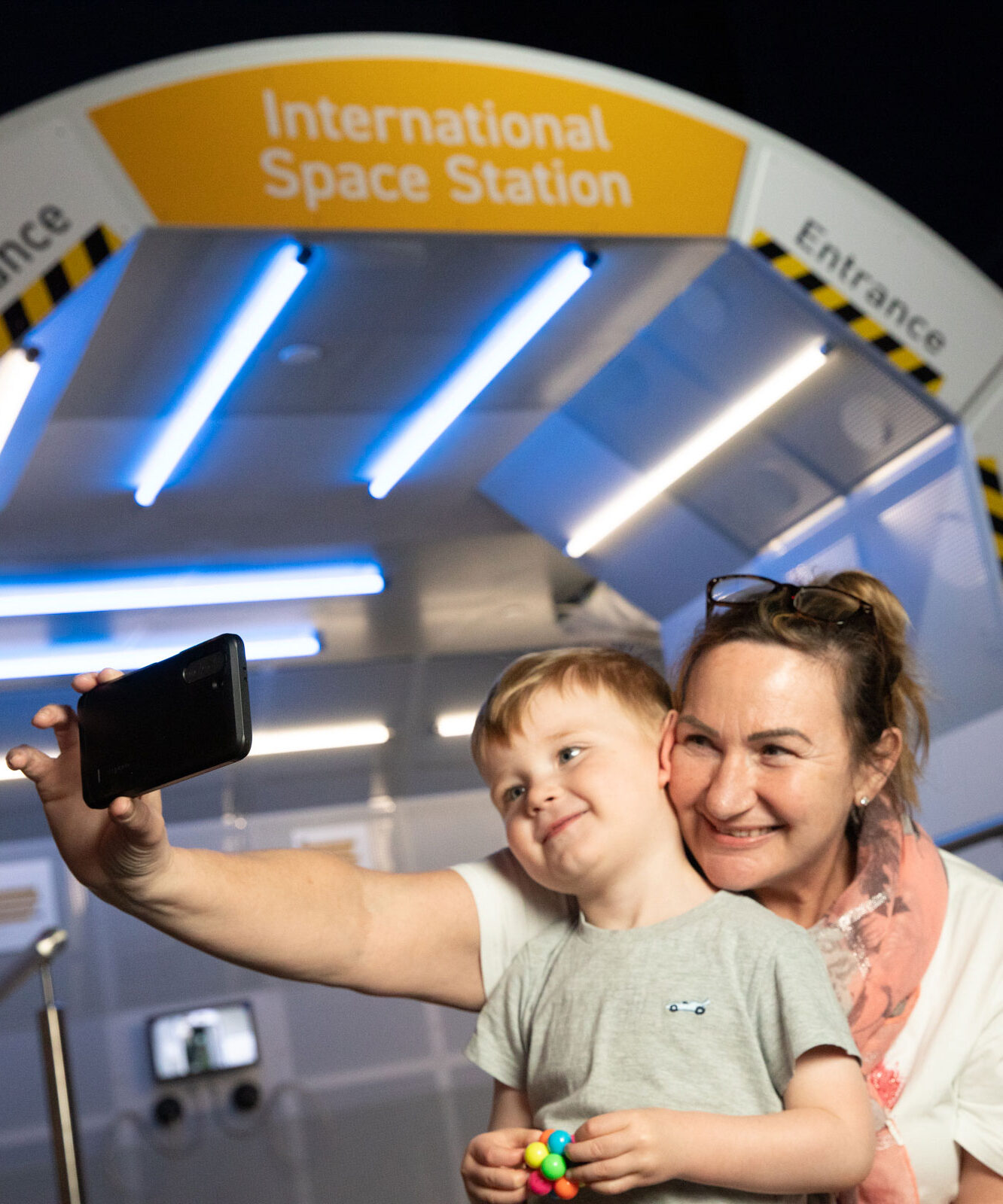 Grandma And Child In Life Science Centre's Space Zone Taking A Selfie In Front Of The Model International Space Station