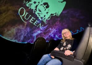 Young girl sat in Life's Planetarium, watching Queen Heaven planetarium show, wearing a Queen T-shirt