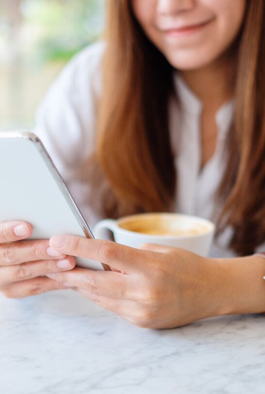 Closeup image of a woman holding and using mobile phone to generate AI images