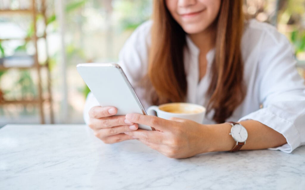 Closeup image of a woman holding and using mobile phone for AI generation