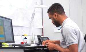 Man at desk looking down at keyboard