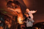 Daughter On Mum's Shoulders In Front Of Huge T. Rex Model