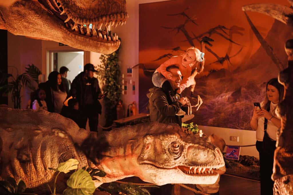 Family taking a photo of a juvenile T. rex at Newcastle's Life Science Centre