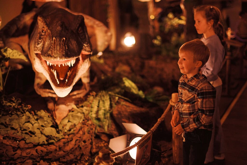 Little boy smiling at a juvenile T. rex at Newcastle's Life Science Centre