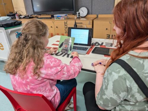Georgia Wright showing a child a picture of a teddy suspect as part of her research