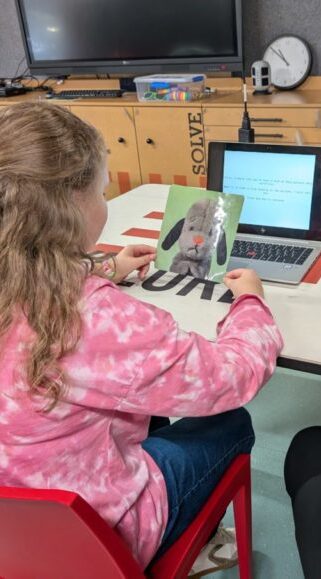 Georgia Wright showing a child a picture of a teddy suspect as part of her research