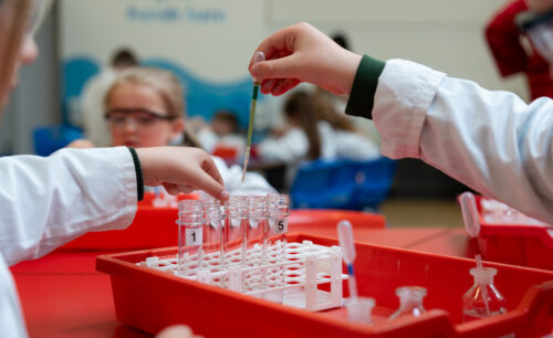 Children's hands using test tubes and pipettes