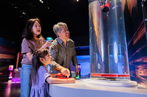 Grandparents with little girl creating a whirlpool at Newcastle's Life Science Centre.