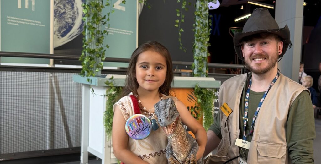 Dino Ranger Jake Morton pictured with little girl holding dinosaur figure.