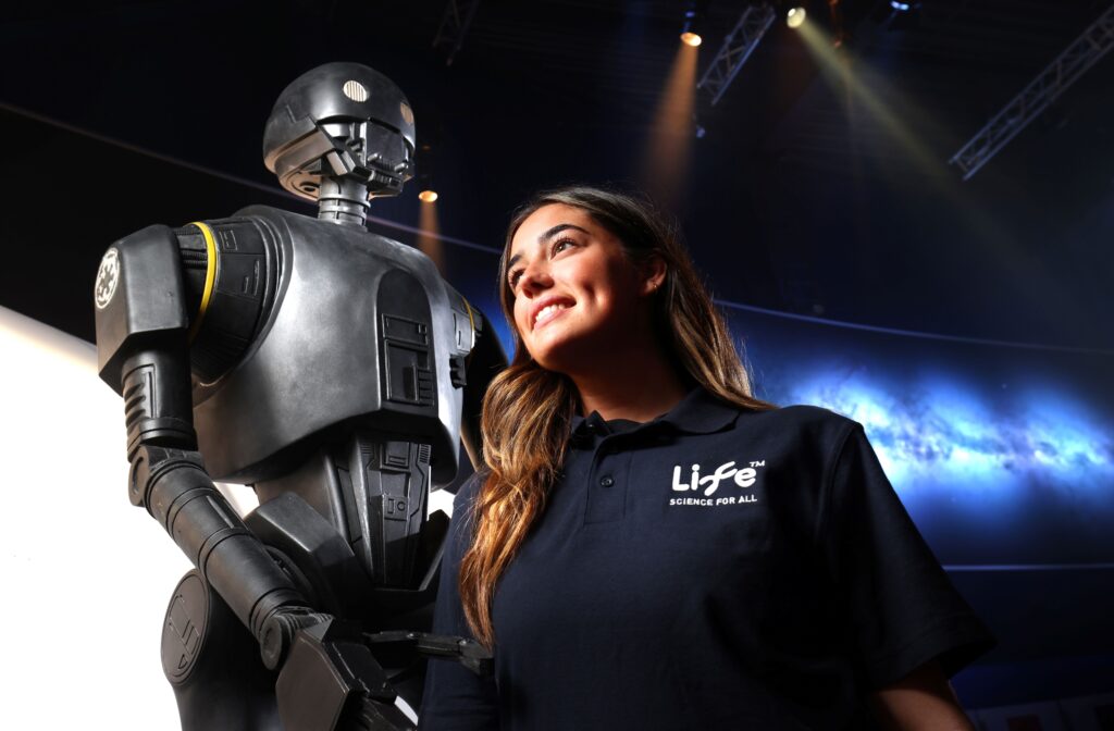 Member of Newcastle's Life Science Centre stood next to Star Wars droid.